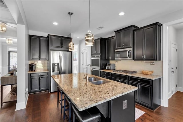 2953 Balvenie Pl, Acworth, GA 30101 - kitchen with appliances with stainless steel finishes, a sink, light stone countertops, backsplash, and a kitchen island with sink