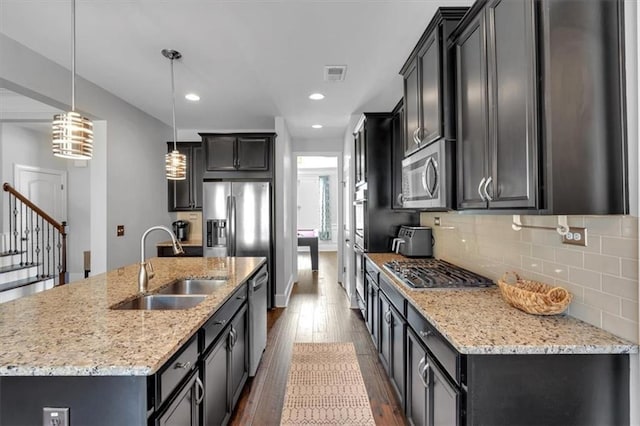 2953 Balvenie Pl, Acworth, GA 30101 - kitchen with stainless steel appliances, a sink, dark wood-style floors, backsplash, and a kitchen island with sink
