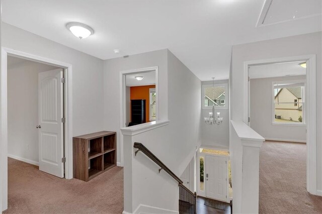 822 Pine Way, Dallas, GA 30157 - corridor featuring a notable chandelier, an upstairs landing, attic access, baseboards, and carpet