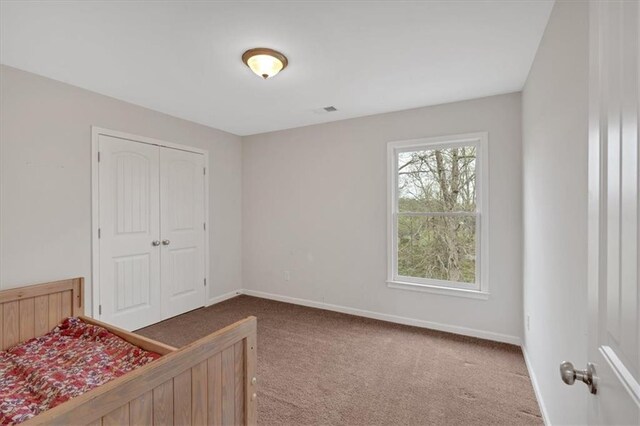 822 Pine Way, Dallas, GA 30157 - unfurnished bedroom featuring a closet, carpet, baseboards, and visible vents