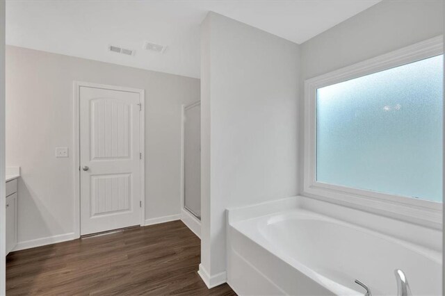 822 Pine Way, Dallas, GA 30157 - full bath with a stall shower, vanity, a garden tub, wood finished floors, and visible vents