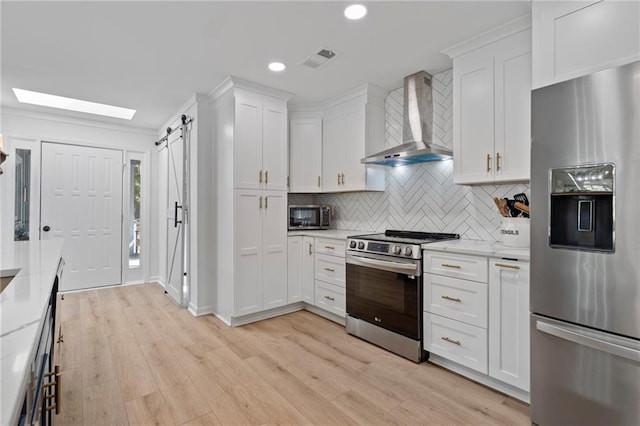 114 Narrows Loop, Waleska, GA 30183 - kitchen with stainless steel appliances, wall chimney range hood, a barn door, white cabinets, and recessed lighting