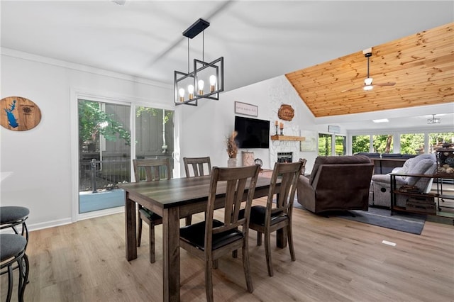114 Narrows Loop, Waleska, GA 30183 - dining room with a stone fireplace, a chandelier, light wood-type flooring, vaulted ceiling, and baseboards