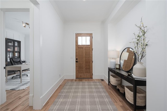 entryway featuring crown molding and wood-type flooring