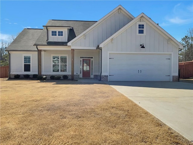 view of front of home featuring a front lawn, driveway, board and batten siding, an attached garage, and brick siding