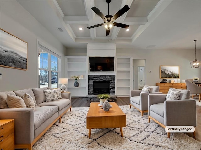 living room featuring wood finished floors, visible vents, coffered ceiling, beam ceiling, and a fireplace