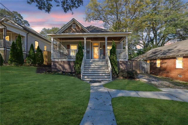 bungalow-style home featuring a porch and a yard