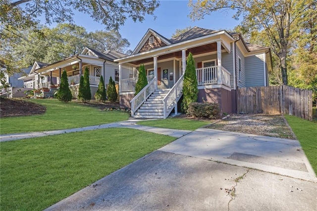 bungalow-style house featuring covered porch and a front yard