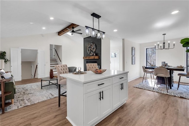 kitchen with white cabinetry, decorative light fixtures, light hardwood / wood-style flooring, and a kitchen island