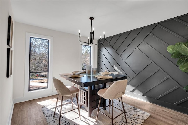dining room with a chandelier, wood finished floors, and baseboards