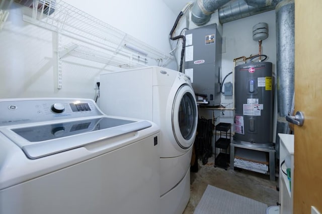 washroom with water heater, laundry area, washing machine and dryer, and heating unit