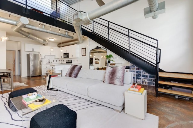 living area with stairs and a towering ceiling