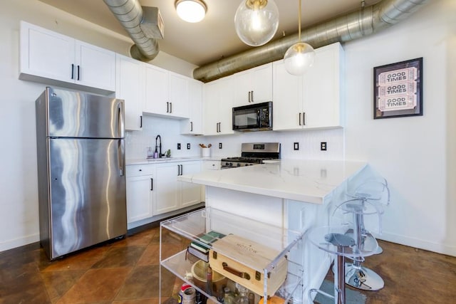 kitchen with white cabinets, backsplash, appliances with stainless steel finishes, and a sink