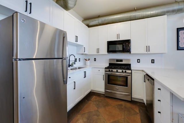 kitchen featuring white cabinetry, light stone countertops, stainless steel appliances, and a sink