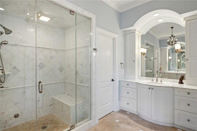 bathroom featuring vanity, decorative columns, an inviting chandelier, and independent shower and bath