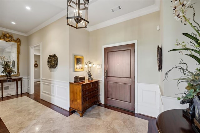 entryway featuring crown molding and an inviting chandelier