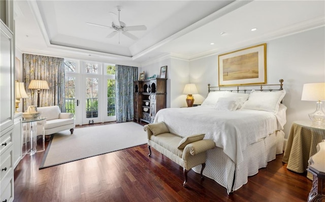 bedroom featuring a raised ceiling, wood finished floors, a ceiling fan, and ornamental molding