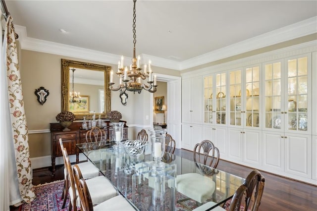 dining room with an inviting chandelier, dark wood-type flooring, and ornamental molding