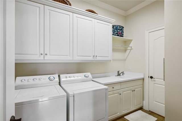 laundry area with washing machine and dryer, a sink, ornamental molding, and cabinet space