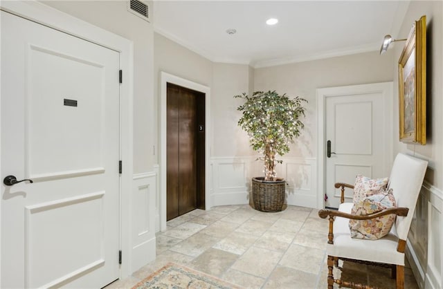 interior space featuring a decorative wall, ornamental molding, visible vents, wainscoting, and elevator