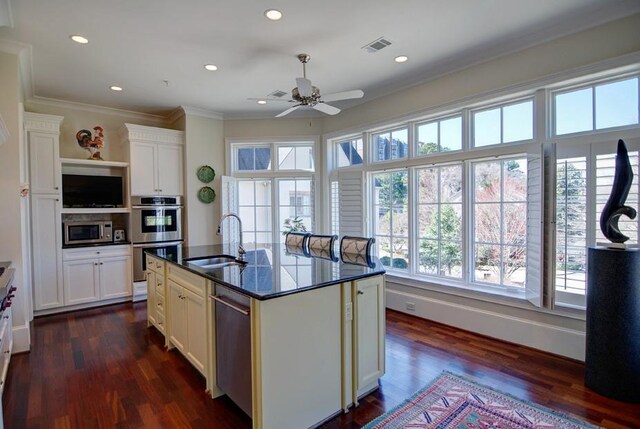 kitchen with a kitchen island with sink, sink, ceiling fan, dark hardwood / wood-style flooring, and stainless steel appliances