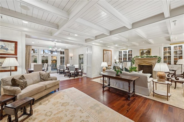 living room with a notable chandelier, hardwood / wood-style flooring, and beamed ceiling