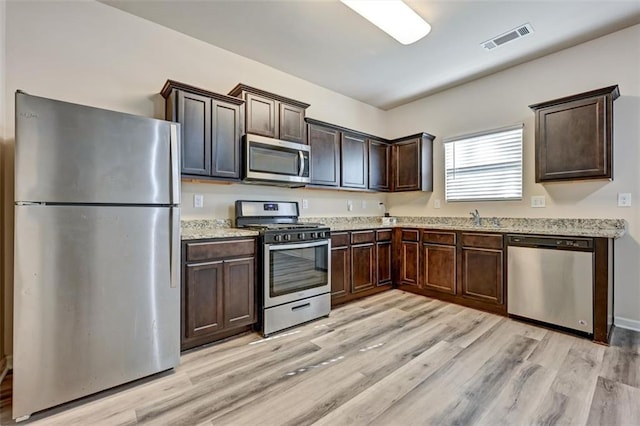 kitchen featuring light hardwood / wood-style flooring, stainless steel appliances, dark brown cabinets, and sink