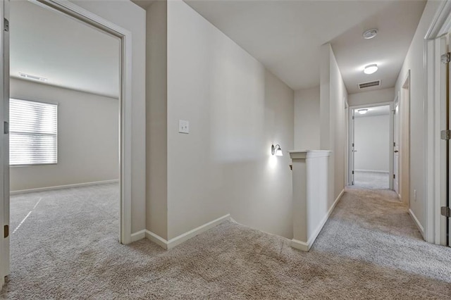 corridor featuring light colored carpet