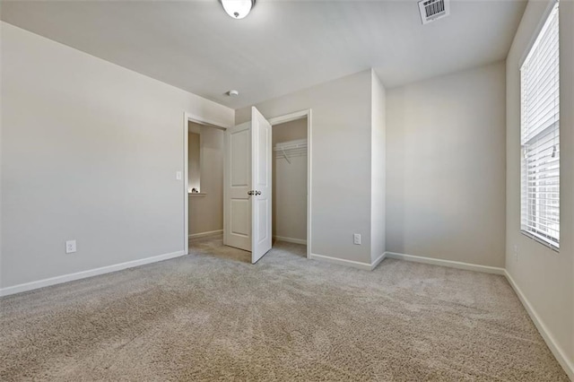 unfurnished bedroom featuring light colored carpet and a closet