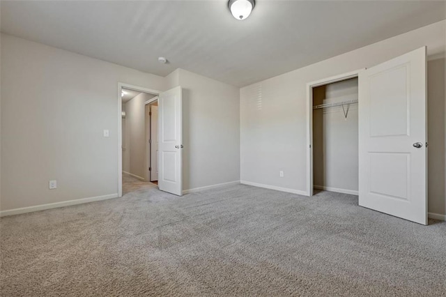 unfurnished bedroom with light colored carpet and a closet