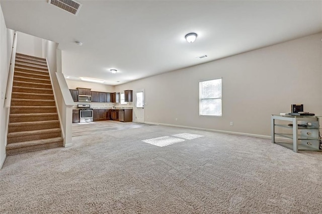 unfurnished living room featuring light carpet