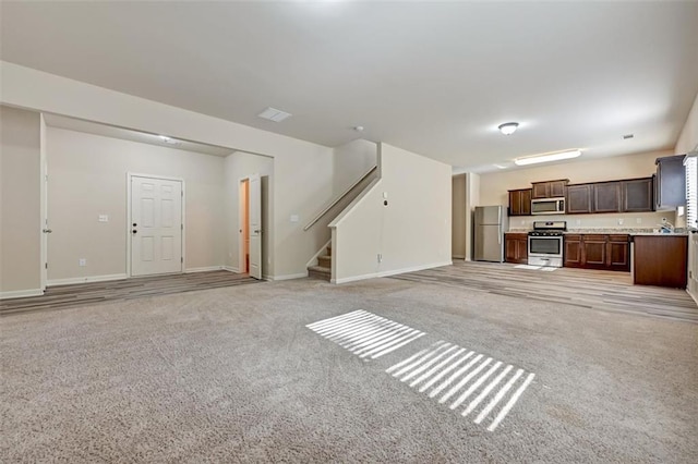 unfurnished living room featuring light colored carpet