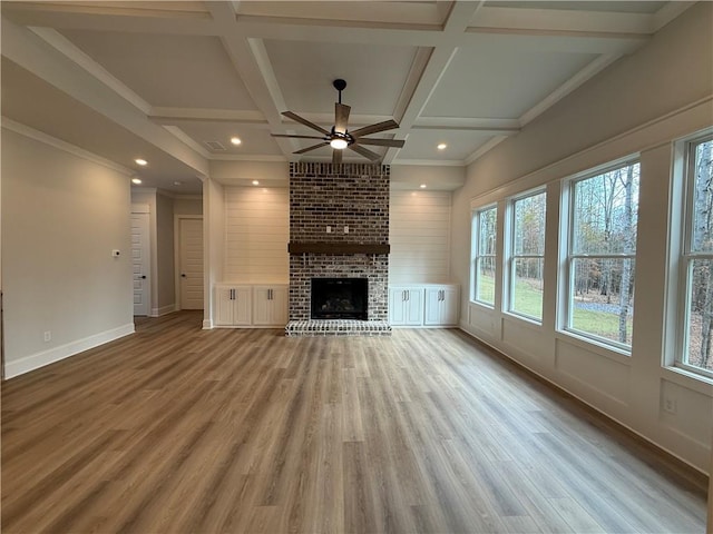 unfurnished living room featuring ceiling fan, hardwood / wood-style floors, coffered ceiling, and a brick fireplace