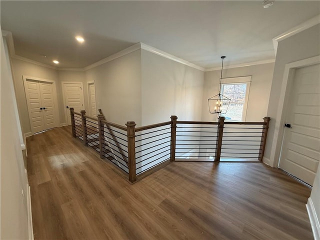 corridor featuring a chandelier, hardwood / wood-style flooring, and ornamental molding