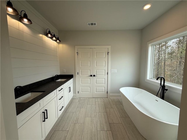 bathroom with vanity and a bath