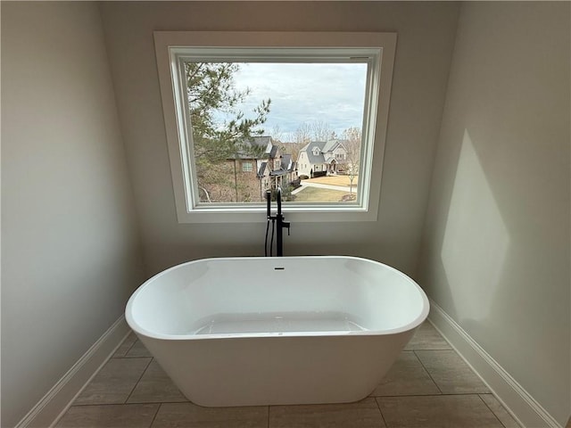 bathroom with a tub to relax in and tile patterned flooring