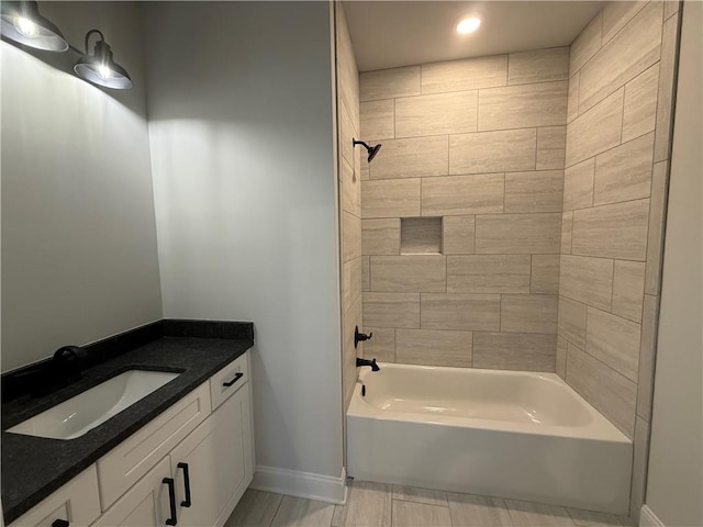 bathroom featuring vanity and tiled shower / bath