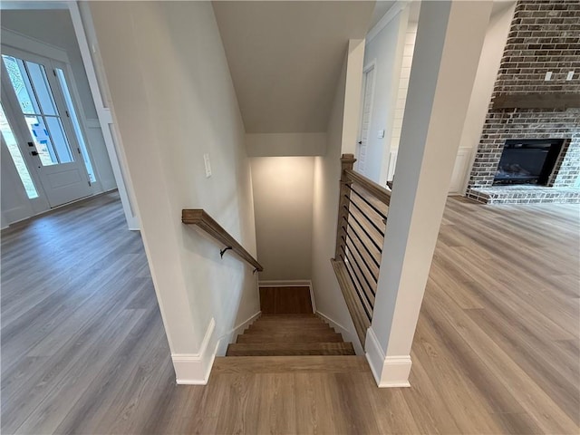 stairway featuring a fireplace and hardwood / wood-style flooring