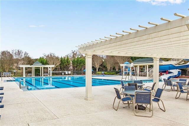 view of swimming pool featuring a pergola, a patio, and a water slide