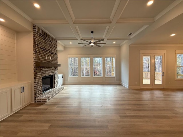 unfurnished living room featuring a brick fireplace, ceiling fan, coffered ceiling, and light hardwood / wood-style flooring