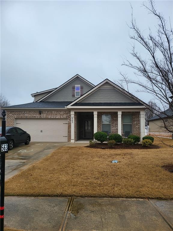 view of front facade featuring an attached garage, concrete driveway, and brick siding