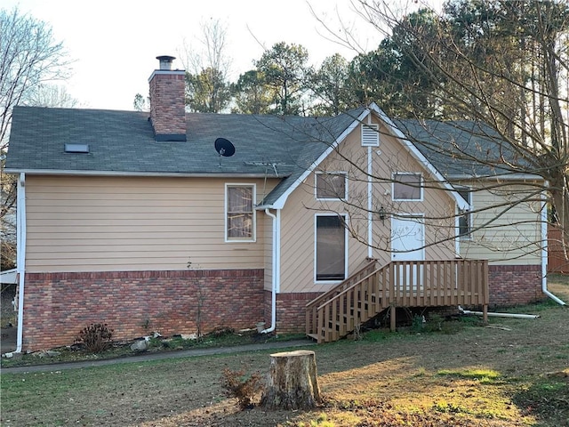 rear view of house with a lawn and a deck