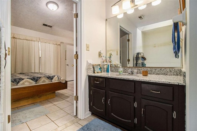 bathroom featuring tile patterned flooring, vanity, and a textured ceiling