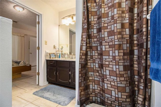 bathroom featuring vanity, tile patterned flooring, and a textured ceiling