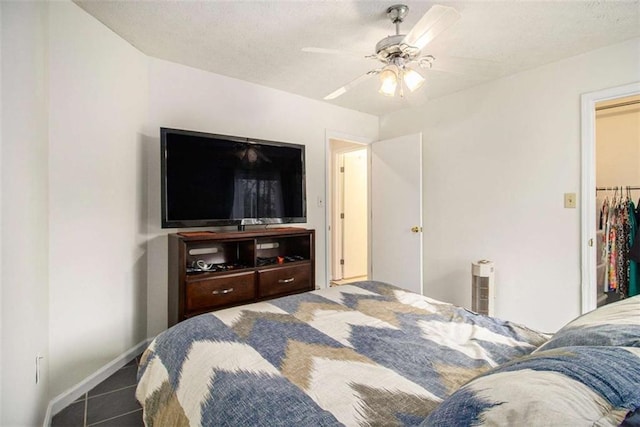 bedroom with ceiling fan, tile patterned flooring, a closet, and a walk in closet