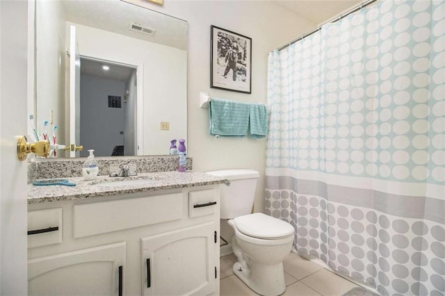 bathroom featuring vanity, toilet, and tile patterned flooring