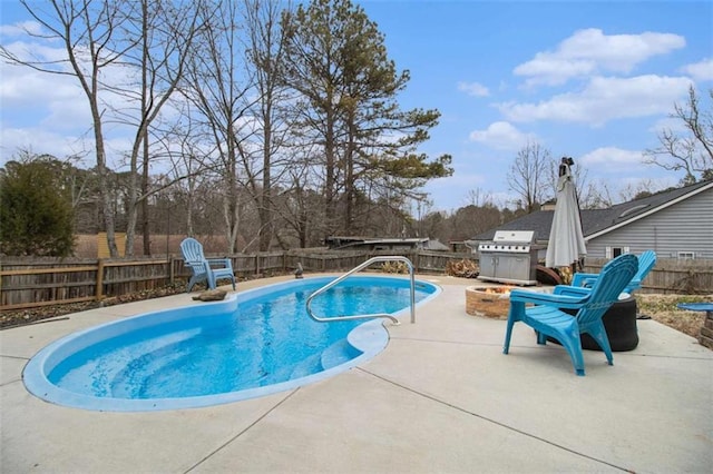 view of pool with a patio, grilling area, and an outdoor fire pit