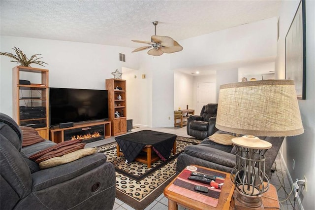 living room featuring ceiling fan, vaulted ceiling, and a textured ceiling