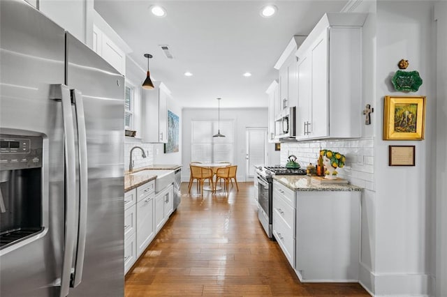 352 Davis St, Monroe, GA 30655 - kitchen featuring white cabinets, a sink, visible vents, and stainless steel appliances