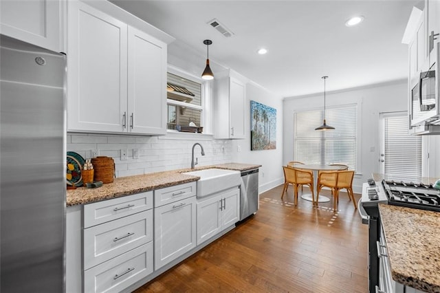 352 Davis St, Monroe, GA 30655 - kitchen featuring white cabinets, visible vents, decorative backsplash, stainless steel appliances, and a sink